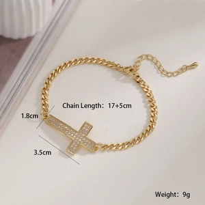 Détail macro du bracelet croix plaqué or 18 carats avec sertissage de zircons blancs