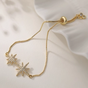 Elegant 18K gold plated double row bracelet with starburst pendants and white zirconias