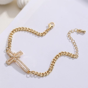 Détail macro du pendentif croix plaqué or 18K avec zircons blancs sur chaîne cubaine