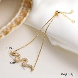 Dettaglio macro del bracciale a serpente in oro 18K con occhi verdi e zirconi