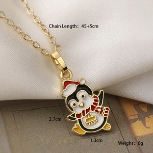 Macro shot of gold-plated penguin necklace detail with enamel scarf and size labels