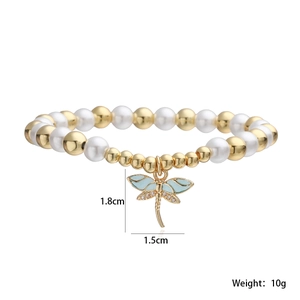 Détail du pendentif libellule plaqué or 18K avec émail bleu et perles sur un bracelet
