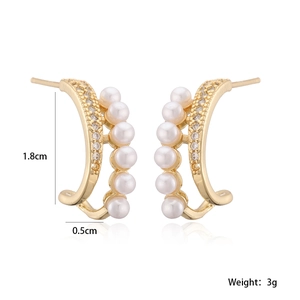 Detail view of gold earrings featuring parallel rows of white pearls and sparkling zircons