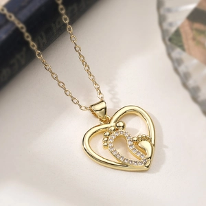 Élégant collier doré avec pendentif cœur ajouré et empreintes de pieds en diamants brillants