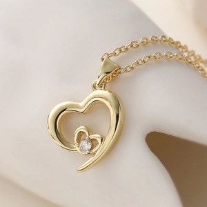 Collier minimaliste à double cœur évidé avec une pierre de zircone scintillante en doré