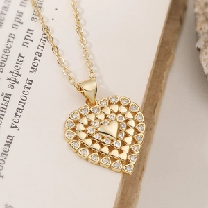 Collar con colgante de corazón chapado en oro de 18K y circón sobre libro antiguo