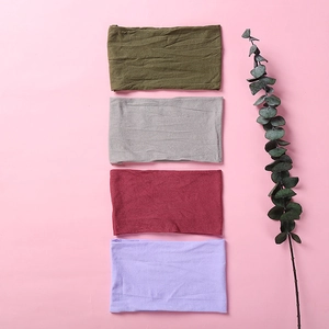 Flat lay of soft nylon headbands in olive, grey, burgundy, and lavender colors