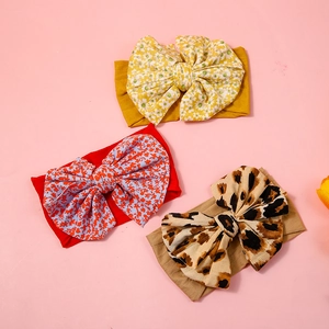 Detailed view of 3-pack baby headbands with leopard print and floral bow patterns
