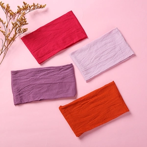 Close-up of four soft nylon headbands in red, lilac, purple, and orange fabric