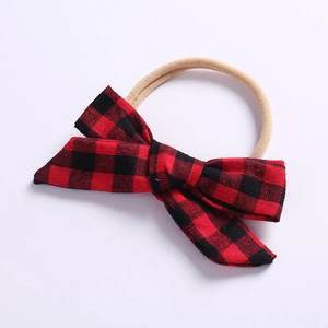 Detail eines Baby Stirnbandes mit rot-schwarzer Karo Schleife und Nylonband