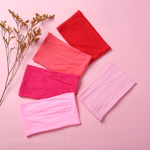 Detail view of five soft nylon baby headbands in various shades of red and pink colors