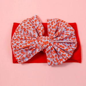 Detail of baby headband with oversized floral bow and soft red nylon high elastic band