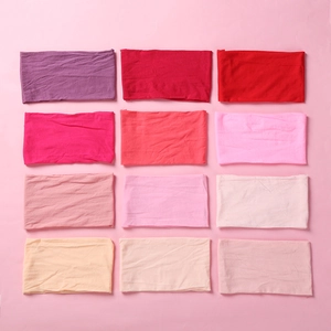 Matrix of 12 soft nylon baby headbands in various pink and red gradient colors
