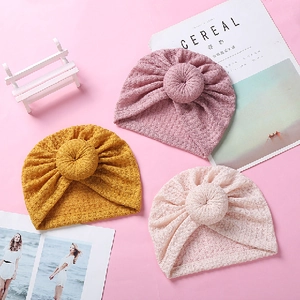 Macro view of waffle knit baby donut turbans in dusty pink, mustard and cream colors