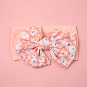 Detail of pink baby headband with large blue floral print bow and soft nylon fabric