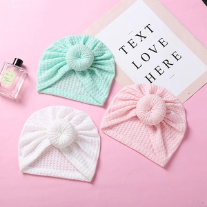 Detail of baby turban hats in mint, pink and white with a soft waffle knit donut knot design