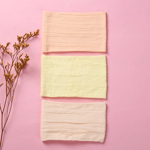 Detail of three soft jacquard nylon baby headbands in pink and yellow knit texture