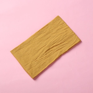 Detail view of mustard yellow stretch nylon headband with ribbed texture for kids