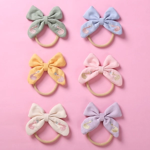 Détail de 6 bandeaux bébé avec broderie de cygne et couronnes sur bandes en nylon souple