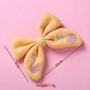 Détail pince à cheveux nœud jaune avec broderie cygne rose et dimensions du produit