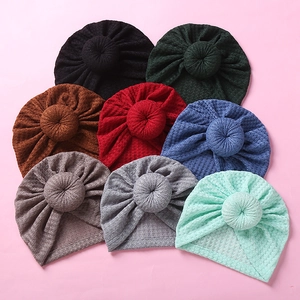Flat lay of colorful waffle knit baby donut turbans in eight different vibrant shades