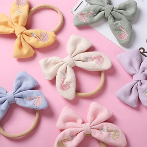 Détail de six bandeaux à nœuds brodés colorés avec motifs de cygne sur bandes en nylon