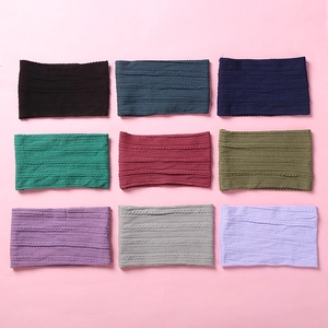 Detail showing nine colorful cable-knit nylon baby headbands in a 3x3 grid layout