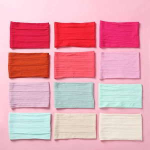 Flat lay of soft jacquard nylon baby headbands in 12 assorted colors with cable knit texture