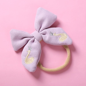 Détail du bandeau bébé avec cygne et couronne brodés lilas sur ruban en nylon souple