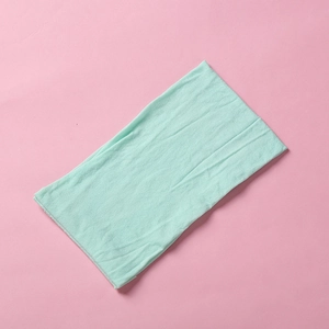 Macro detail of mint green soft nylon headband showing fine knit texture and elasticity