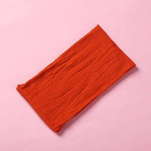 Macro texture showing soft orange nylon knit fabric with horizontal weave pattern