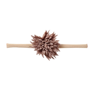 Detailed close-up of a soft pink fabric flower on a flexible nylon baby headband