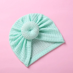Detailed close-up of mint green waffle knit fabric and donut knot on infant turban hat
