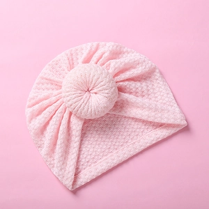 Detailed view of pink waffle knit baby hat with donut knot and breathable mesh texture
