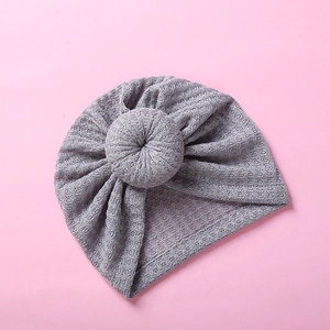 Close-up of grey waffle knit baby turban hat with a cute donut knot design for infants