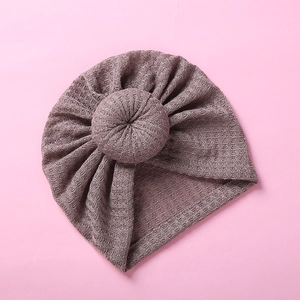 Detailed waffle texture and cute donut knot design on this soft pink infant beanie hat