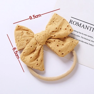Fascia per neonati in cotone giallo ricamato con eleganti motivi floreali a fiocco