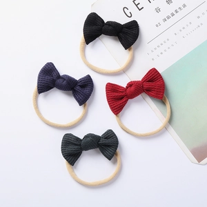 Detail of four-piece waffle knit baby bow headbands in dark tones with nylon bands