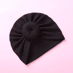 Detailed top view of black waffle knit baby turban hat with a cute donut knot decoration
