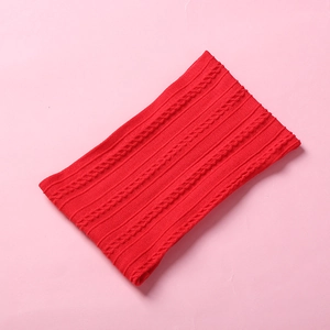 Detailed view of red chunky cable knit infinity scarf made of soft yarn for winter