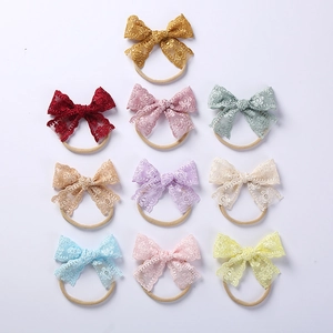 Detailed close-up of 10-piece baby nylon headbands with floral lace embroidery bows