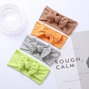 Set of four ribbed knit baby headbands with large bows in coffee, orange, gray and green