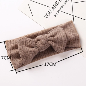 Détail du bandeau bébé marron 7x17cm avec grand nœud tricoté et texture jacquard côtelée