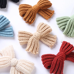 Gros plan de barrettes à nœuds tricotés main en laine épaisse aux couleurs variées