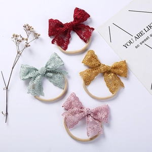 Detailed close-up of soft lace embroidery bows on elastic nylon baby headbands in four colors