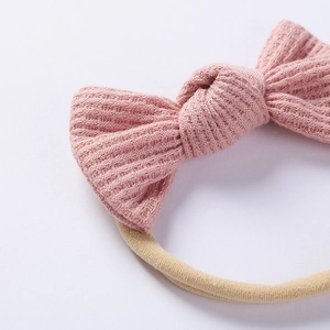 Close-up of pink ribbed knit bow with soft elastic headband for infants and babies