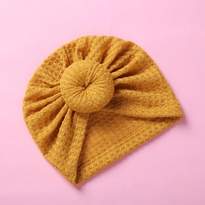 Close-up detail of mustard yellow waffle knit fabric and donut knot on infant turban hat