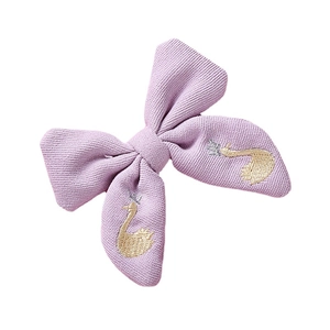 Barrette nœud tricoté lavande pour filles avec broderie cygne doré sur fond blanc pur
