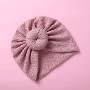 Close-up of baby waffle knit donut turban hat in dusty rose pink with textured fabric