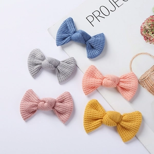 Detail view of waffle knit bow hair clips in five soft colors for girls and toddlers